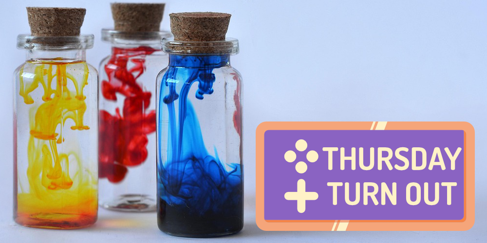 A stock photograph showing three glass bottles with cork stoppers. Each bottle has a dye (from left to right: yellow, red, blue) dissolving into water.